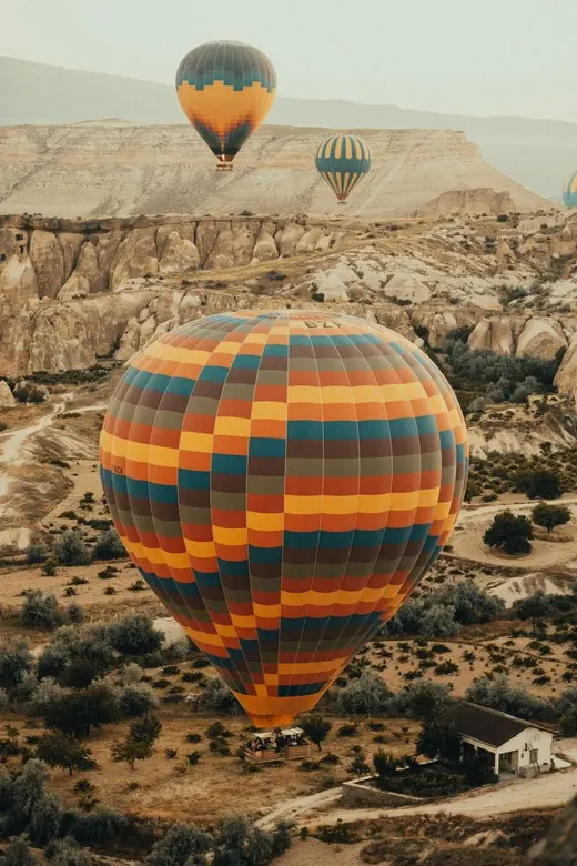 Striped hot air balloon over Cappadocia at sunrise